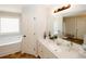 Bright bathroom featuring a soaking tub, stylish vanity with marble countertop, and decorative fixtures at 139 6Th St, Auburn, GA 30011