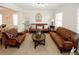Bright, carpeted living room boasts brown leather seating and decorative accents at 139 6Th St, Auburn, GA 30011