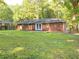 Expansive backyard with a well-maintained lawn, mature trees, and a brick patio at 2764 Riggs Dr, Atlanta, GA 30344