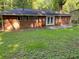 Spacious backyard with a lush lawn, mature trees, brick exterior and a concrete patio at 2764 Riggs Dr, Atlanta, GA 30344