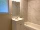 This bathroom features a white vanity and a bathtub with tiled walls at 2764 Riggs Dr, Atlanta, GA 30344