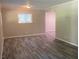 Open living room design with gray plank floors and neutral paint, brightened by natural light from large windows at 2764 Riggs Dr, Atlanta, GA 30344