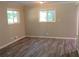 Living room featuring gray plank flooring, neutral walls, and bright natural light from two windows at 2764 Riggs Dr, Atlanta, GA 30344