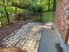Stone patio extending from a brick home, surrounded by a wooden fence and lush trees at 2764 Riggs Dr, Atlanta, GA 30344
