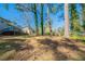Large backyard featuring a tree canopy, raised deck, and partial house views at 8904 Creekwood Ct, Riverdale, GA 30274