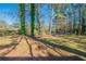 Large backyard featuring tall trees and grass at 8904 Creekwood Ct, Riverdale, GA 30274