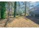 Spacious backyard featuring a tree canopy and building in the background at 8904 Creekwood Ct, Riverdale, GA 30274