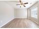 Empty bedroom featuring wood-look floors, two windows with blinds, and a ceiling fan at 8904 Creekwood Ct, Riverdale, GA 30274