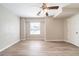 This bedroom has neutral walls, light-colored wood-look floors, and a ceiling fan with lights at 8904 Creekwood Ct, Riverdale, GA 30274
