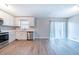 Kitchen and dining area featuring white cabinets, stainless steel appliances, and light wood flooring at 8904 Creekwood Ct, Riverdale, GA 30274