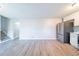 A spacious open-plan kitchen space with light wood floors, stainless steel refrigerator, and light-colored walls at 8904 Creekwood Ct, Riverdale, GA 30274