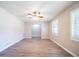 Empty living room featuring light wood floors, neutral-painted walls, a ceiling fan, and lots of natural light at 8904 Creekwood Ct, Riverdale, GA 30274