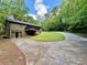 Exterior shot of home showing a two-story deck, walk-out basement, and concrete driveway surrounded by trees at 93 Mill Creek Rd, Hiram, GA 30141