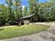 Exterior view of home showing deck, walkout basement, and concrete driveway surrounded by lush trees at 93 Mill Creek Rd, Hiram, GA 30141