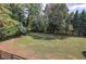 Large backyard with fenced perimeter, mature trees, and grassy area creates a serene and private atmosphere at 1240 Evans Cook Rd, Canton, GA 30115