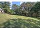 Large grassy backyard with mature trees, fencing, and plenty of space for outdoor activities at 1240 Evans Cook Rd, Canton, GA 30115