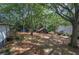 Lovely backyard with a fire pit, stone pathway, shed, and natural wooded scenery at 1240 Evans Cook Rd, Canton, GA 30115