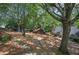 Scenic backyard view featuring a stone pathway, fire pit, shed, and lush greenery at 1240 Evans Cook Rd, Canton, GA 30115