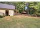 Fenced backyard features a barn and treehouse amid a lawn bordered by mature trees at 1240 Evans Cook Rd, Canton, GA 30115