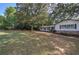 A charming home featuring a well-kept lawn, stone accents, and mature trees providing ample shade at 1240 Evans Cook Rd, Canton, GA 30115