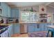 Spacious kitchen featuring wood countertops, blue cabinets, a window over the sink, and stainless-steel appliances at 1240 Evans Cook Rd, Canton, GA 30115