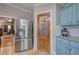 Kitchen area with stainless steel refrigerator, light blue cabinets, and view to the living room at 1240 Evans Cook Rd, Canton, GA 30115