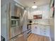 Bright kitchen features stainless steel refrigerator, white cabinetry and wood plank flooring at 1240 Evans Cook Rd, Canton, GA 30115