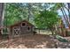 Rustic outbuilding with fenced area, wooden door, and windows, sits among mature trees at 1240 Evans Cook Rd, Canton, GA 30115