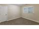 Neutral bedroom with carpet, window, and door to hallway at 2303 Pinewood Dr, Decatur, GA 30032