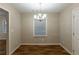 Open dining area with modern chandelier lighting, bright natural light, and stylish hardwood flooring at 2303 Pinewood Dr, Decatur, GA 30032