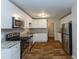 Open kitchen featuring stainless appliances, granite countertops, white cabinets and modern hardwood floors at 2303 Pinewood Dr, Decatur, GA 30032