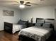 Bedroom with dark wood floors, ceiling fan, and two beds covered with grey linens at 3630 High Point Sw Ln, Atlanta, GA 30331