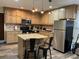 The kitchen showcases tan cabinetry, stainless steel appliances, an island with seating, and a stylish backsplash at 3630 High Point Sw Ln, Atlanta, GA 30331