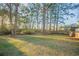 Large grassy backyard with mature trees and partial fencing offers a serene outdoor space at 546 W Sherwood Dr, Riverdale, GA 30274