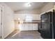 Kitchen featuring white cabinets, laminate countertops, black appliances, and hard surface floors at 546 W Sherwood Dr, Riverdale, GA 30274