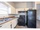 Kitchen featuring white cabinets, laminate countertops, black appliances, and hard surface floors at 546 W Sherwood Dr, Riverdale, GA 30274