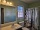 A well-lit bathroom with a sink, window, toilet and shower/tub with curtain at 634 S Jeff Davis S Dr, Fayetteville, GA 30215