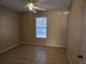 An empty bedroom featuring tile floors, a ceiling fan, and a window with blinds for ample natural light at 634 S Jeff Davis S Dr, Fayetteville, GA 30215