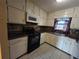 Well-lit kitchen featuring white cabinetry, black appliances, and functional layout at 634 S Jeff Davis S Dr, Fayetteville, GA 30215