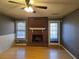 Cozy living room with a brick fireplace, hardwood floors, and plenty of natural light from two windows at 634 S Jeff Davis S Dr, Fayetteville, GA 30215