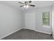 This bedroom features neutral walls, carpet flooring, a ceiling fan, and a window with blinds at 1458 Walnut Log Pl, Austell, GA 30168