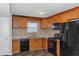 Functional kitchen with wood cabinets, black appliances, and tile backsplash at 1458 Walnut Log Pl, Austell, GA 30168