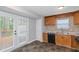 Well-lit kitchen area featuring wood cabinets, stainless steel sink, and doors to the exterior at 1458 Walnut Log Pl, Austell, GA 30168