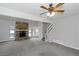 Inviting living room featuring a stone fireplace, ceiling fan, staircase, and lots of natural light at 1458 Walnut Log Pl, Austell, GA 30168