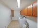 Well-lit laundry room featuring tile floors, ample cabinet storage, and washer and dryer hookups at 210 Cowan Se Rd, Conyers, GA 30094