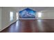 Expansive living area with hardwood floors, neutral paint, and mountain mural for relaxing or entertaining at 210 Cowan Se Rd, Conyers, GA 30094