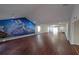 Large living room featuring wood floors and unique mountain mural on the wall at 210 Cowan Se Rd, Conyers, GA 30094