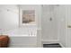 Bathroom featuring a soaking tub, shower and window for natural light at 303 Wood Wind Dr, Woodstock, GA 30189