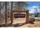 Community entrance sign for Woodwind Station nestled among the trees at 303 Wood Wind Dr, Woodstock, GA 30189