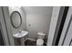 Powder room with pedestal sink and a modern oval mirror at 115 Sunset Ln, Woodstock, GA 30189